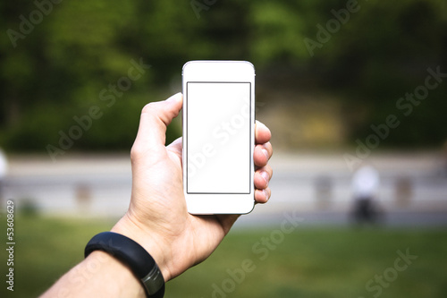 Man using mobile phone in the park as camera