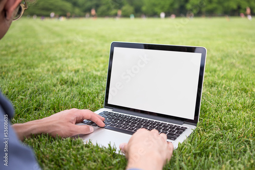 Man using laptop in the park summer