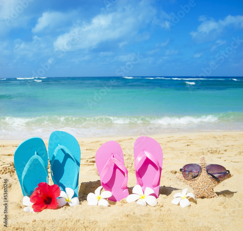 Flip flops and starfish with sunglasses on sandy beach