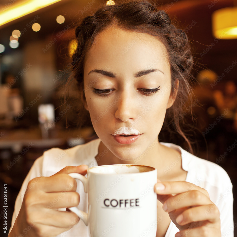 Funny woman with foam from coffee in cafe