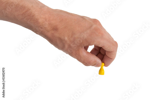 Hand holding a yellow pawn