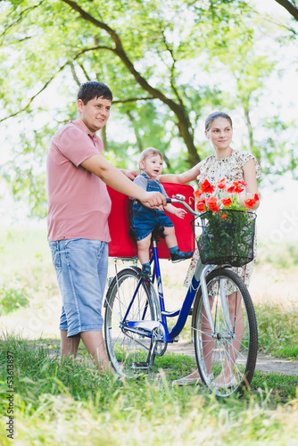 parents carry a child on a bicycle