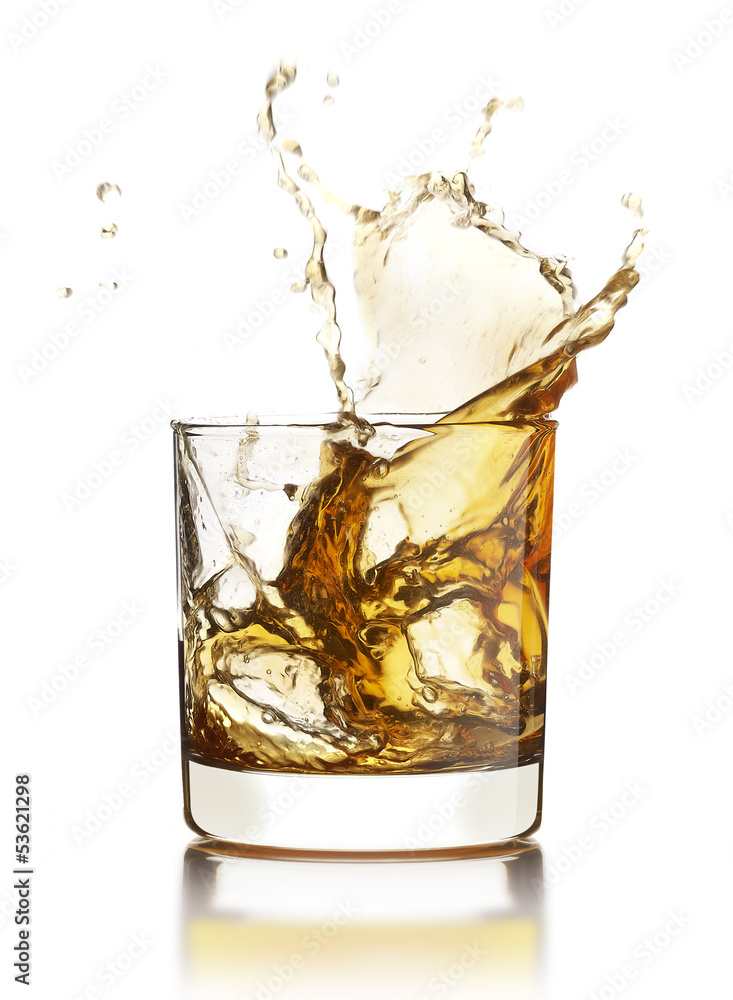 Whisky splashing out of the glass with ice cubes isolated on whi Whisky splashing out of the glass with ice cubes isolated on whi