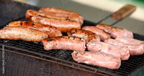 Fresh sausage and hot dogs grilling.