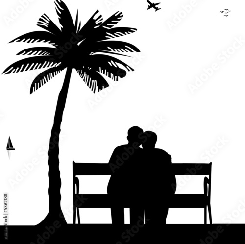 Lovely retired elderly couple sitting on bench on the beach