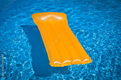 Inflatable mattress floating in a pool
