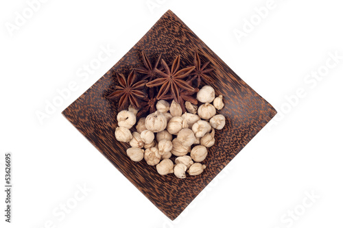 Star anise and camphor seeds on wood plate