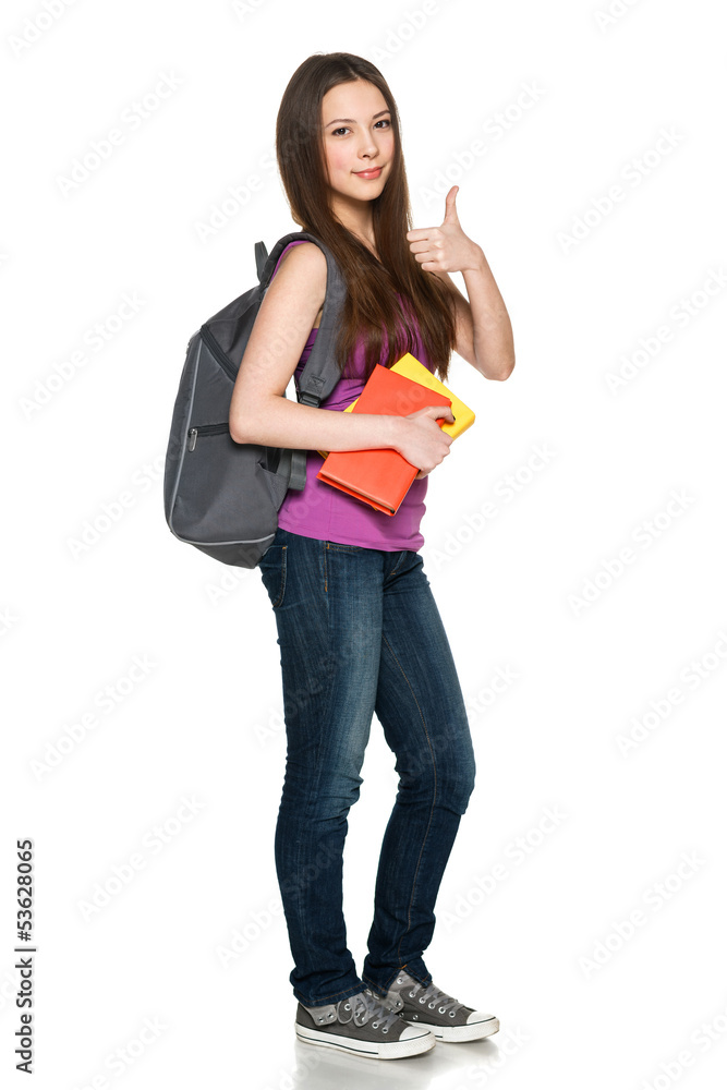 Smiling girl with backpack holding books showing thumb up Smiling girl with backpack holding books showing thumb up