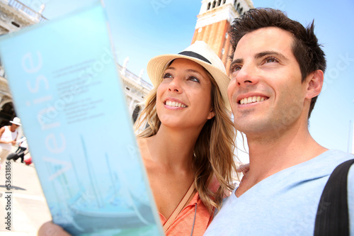 Couple reading tourist guide on San Marco place, Venice photo