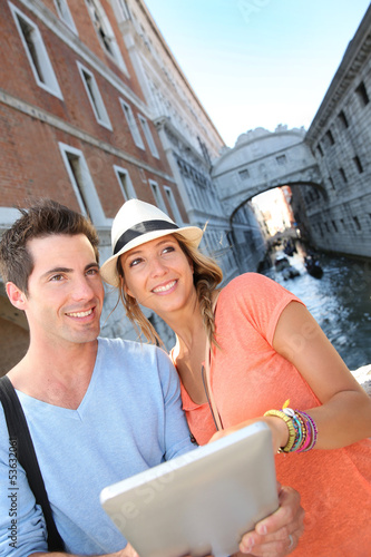 Couple looking at tourist guide by the Bridge of Sighs, Venice © goodluz