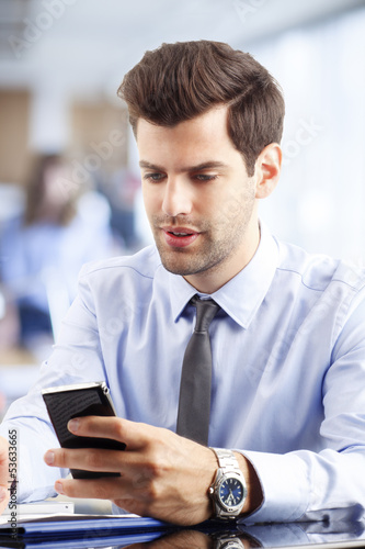 Young businessman reading a text message