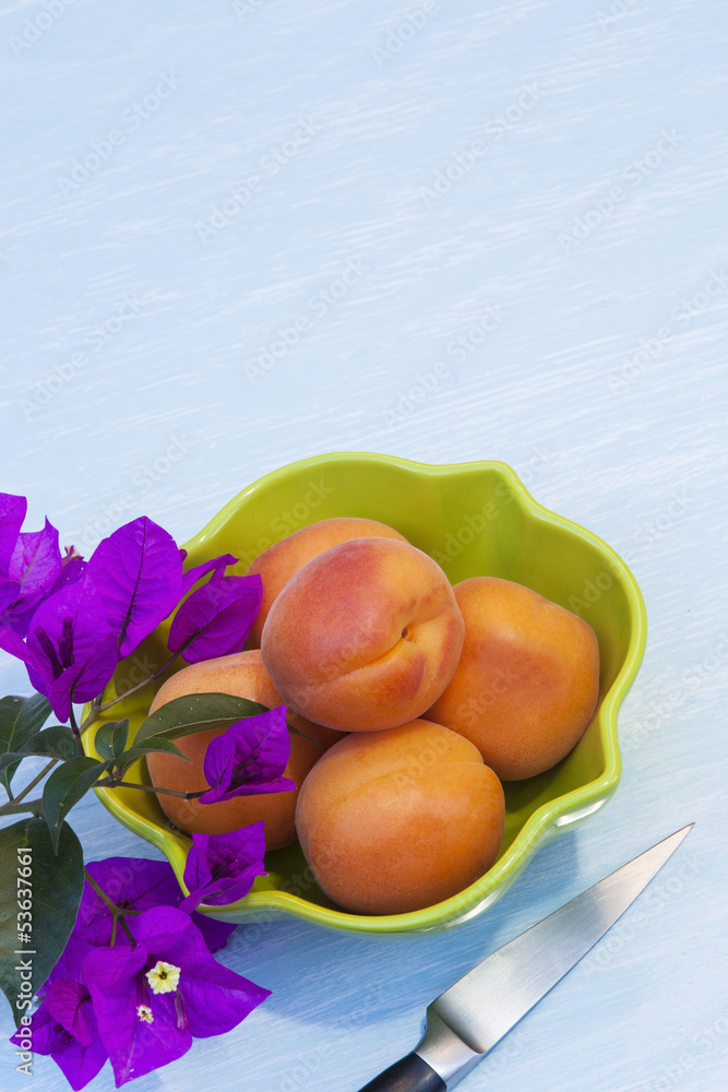 apricots in a green bowl with bougainvillea flowers apricots in a green bowl with bougainvillea flowers