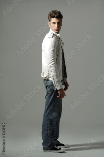 Portrait of a young man standing on gray background © glamour111