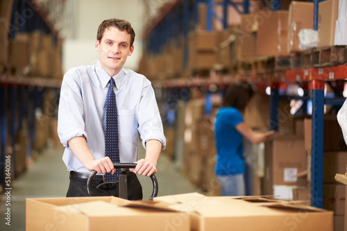 Businessman Pulling Pallet In Warehouse © Monkey Business