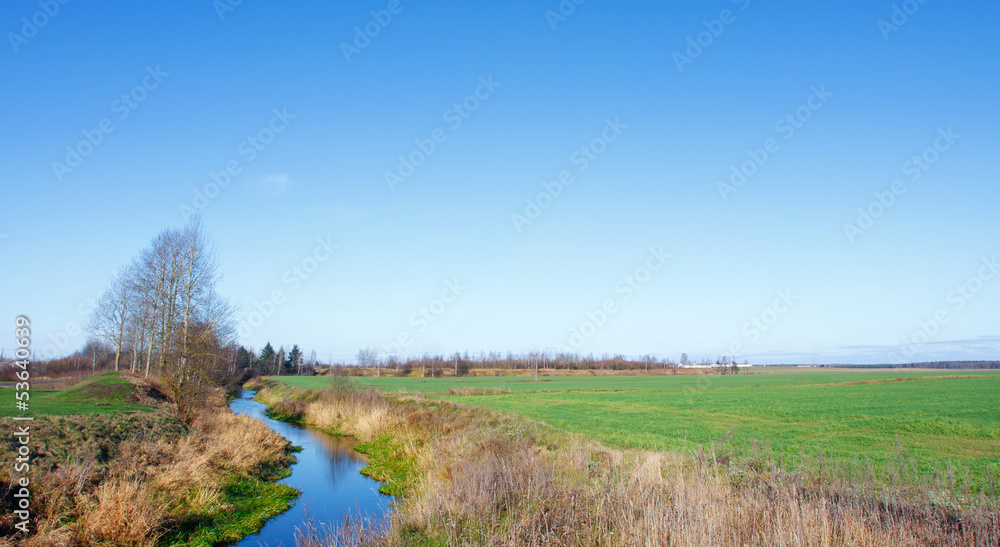 Landscape with a river and a field in a village Landscape with a river and a field in a village