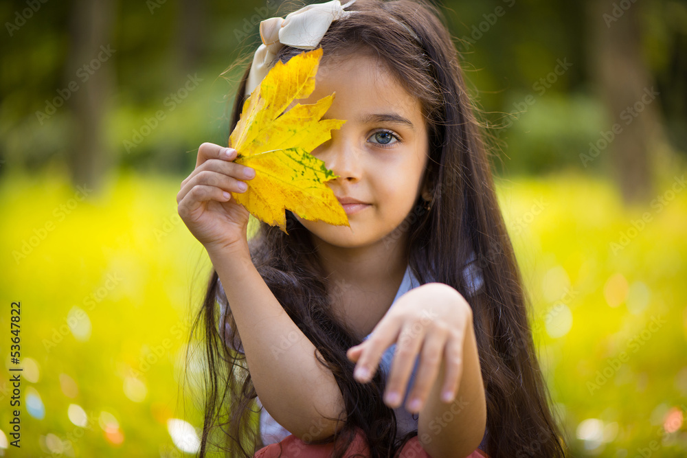 © spass - Cute hispanic girl  hiding over yellow leaf