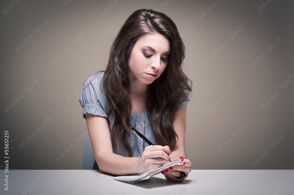 Young girl writing on notebook. Young girl writing on notebook.