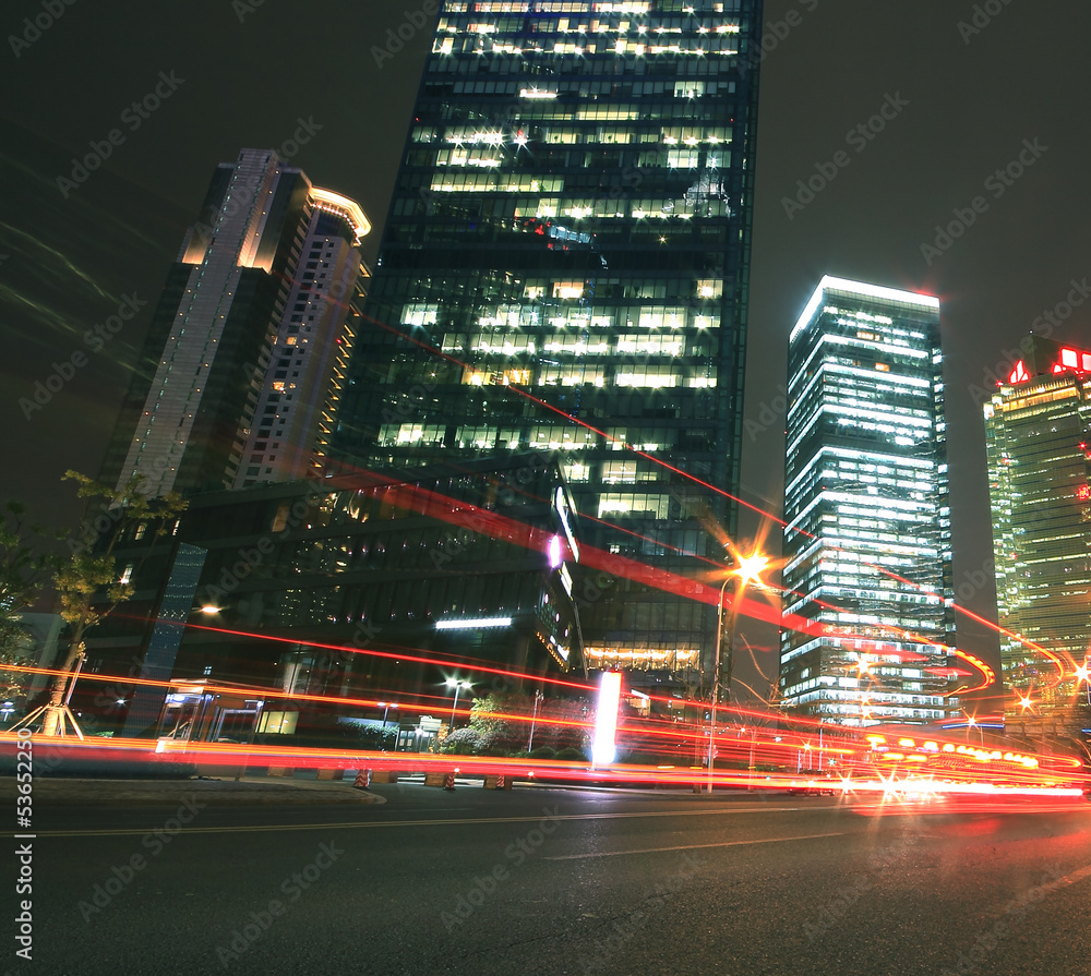 Obraz premium Modern office building background of car night with light trails