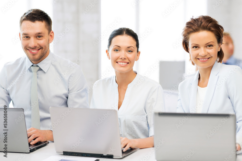 group of people working with laptops in office group of people working with laptops in office