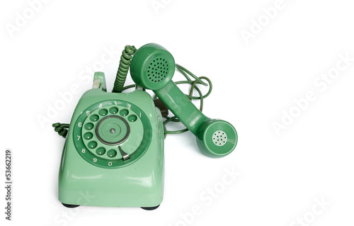 An old green vintage rotary style telephone off the hook