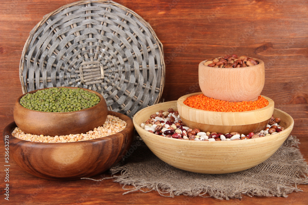 Different kinds of beans in bowls on wooden background Different kinds of beans in bowls on wooden background