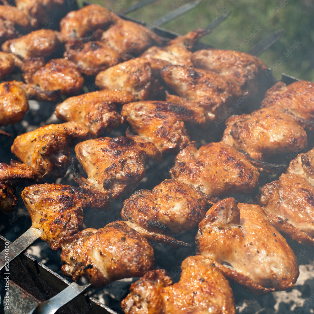 Cooking delicious juicy chicken wings at outdoors grill Cooking delicious juicy chicken wings at outdoors grill