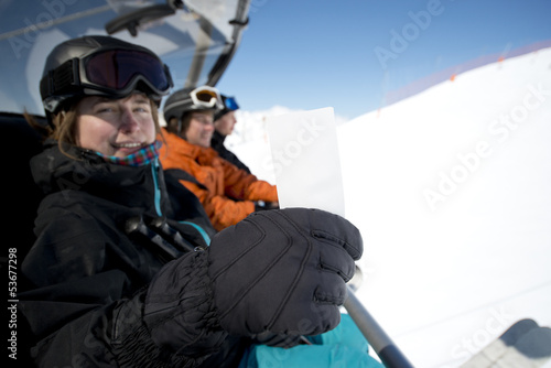 Winter sport girl in chair lift with ticket