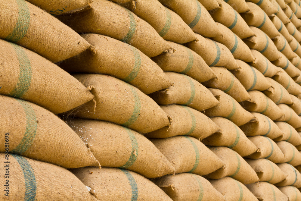Old hemp sacks containing rice placed profoundly stacked