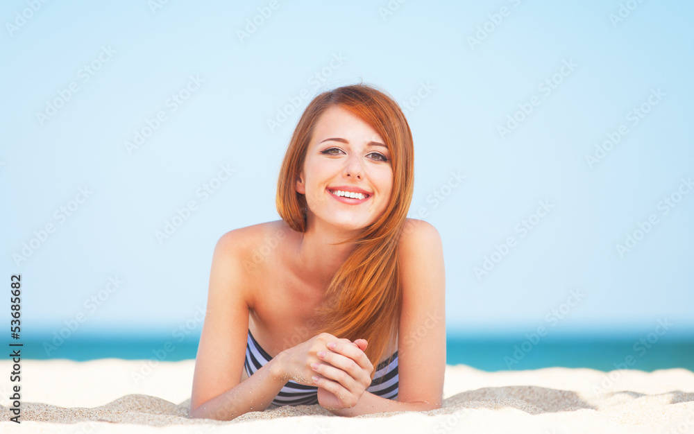 Redhead girl on the beach in spring time.