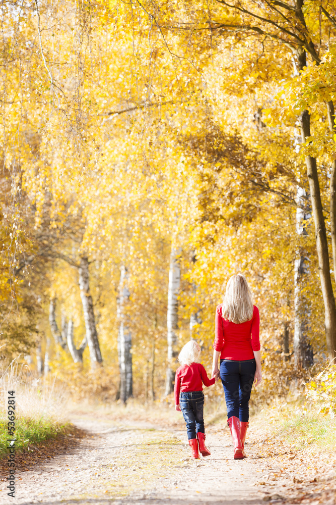 mother with her daughter in autumnal alley mother with her daughter in autumnal alley