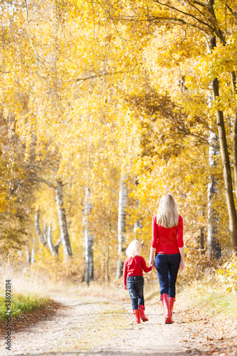 mother with her daughter in autumnal alley