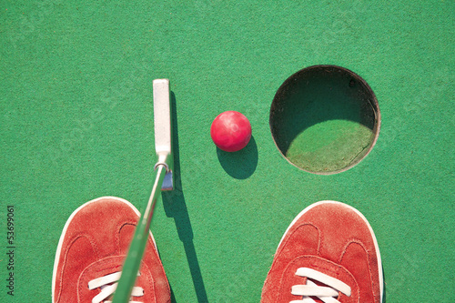 Close-up of miniature golf hole with bat and ball photo