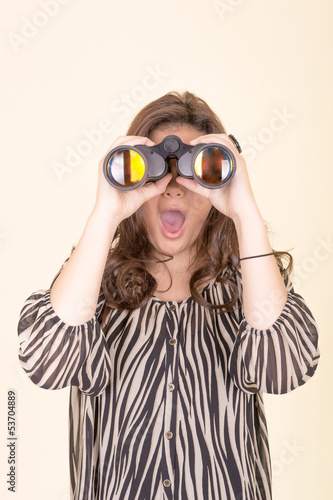 cute woman holding binoculars, yellow background
