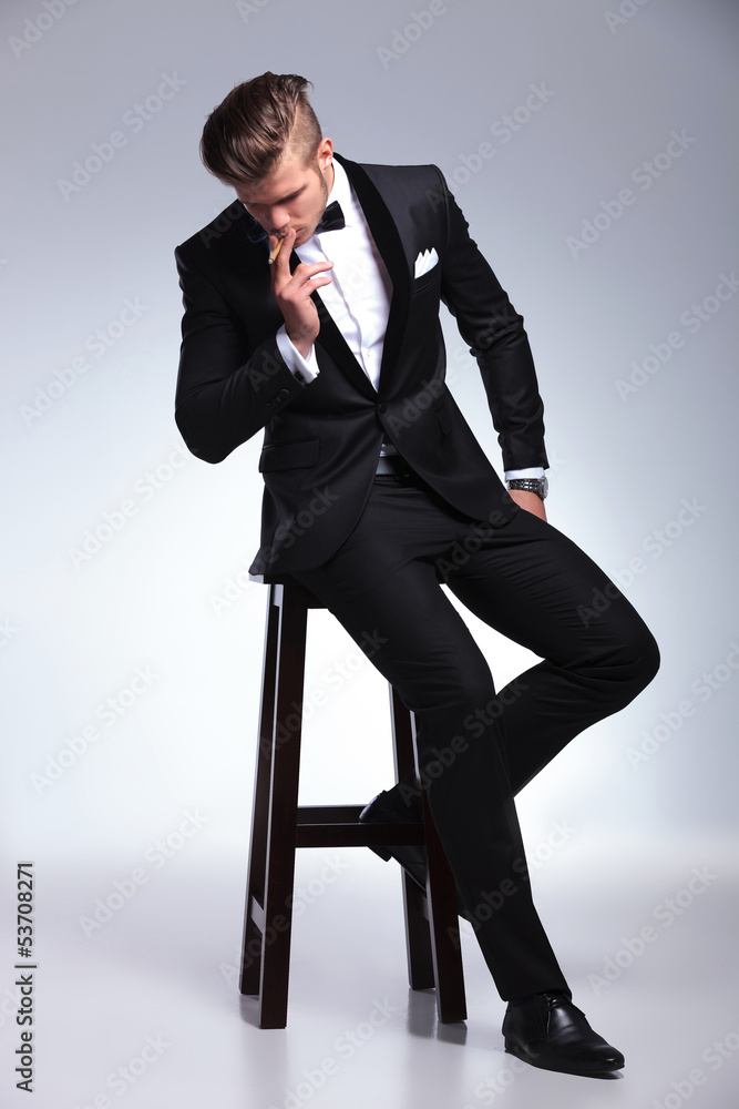 business man on stool smoking and looking down