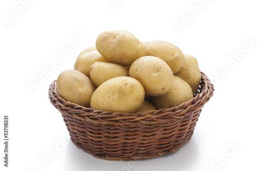 raw potatoes in basket on white background