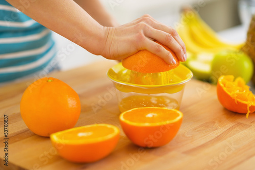 Closeup on woman making orange juice