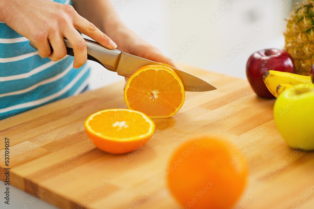 Naklejka premium Closeup on woman cutting orange