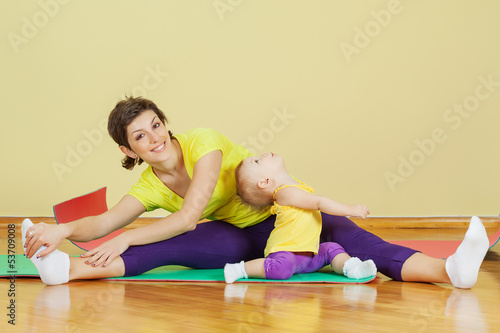 Mother do phisical exercises with her daughter at home