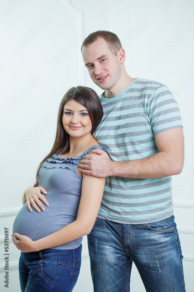Pregnant couple posing at studio Pregnant couple posing at studio