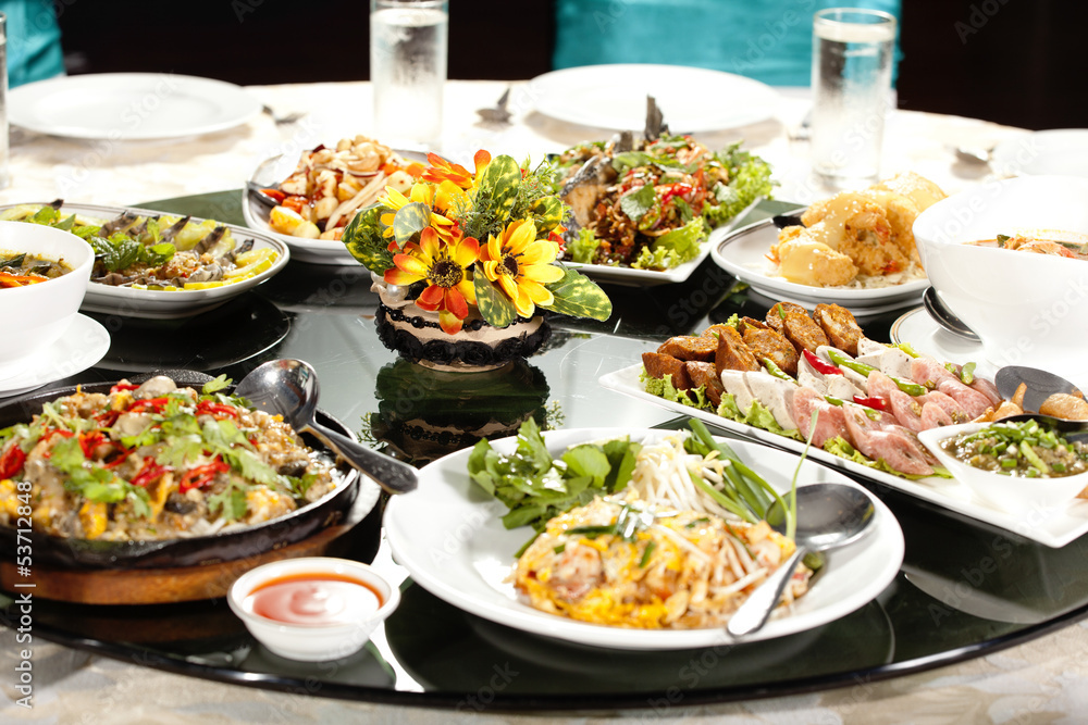 meal time, full round table with colorful food in restaurant meal time, full round table with colorful food in restaurant