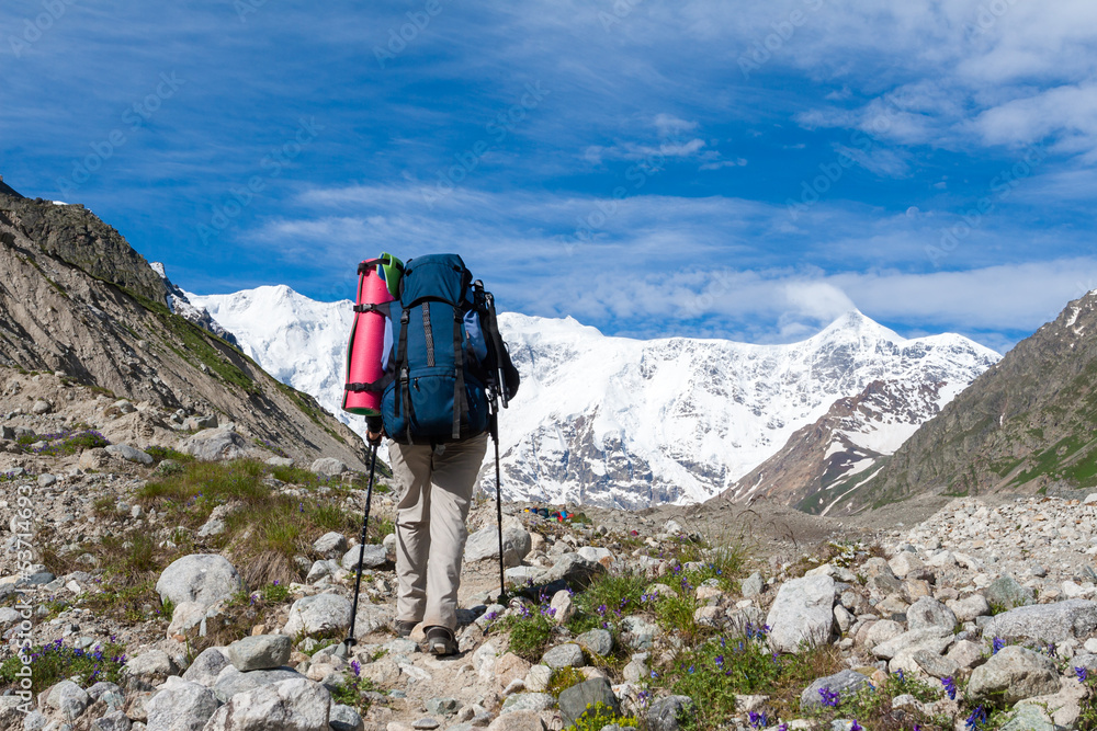 Fototapeta premium Hikier is approaching wall covered with snow in Caucasus mountai