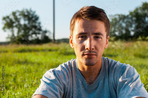 portrait of a handsome young man in a park