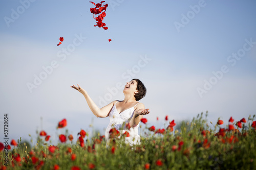 Young casual woman relaxing in poppy field