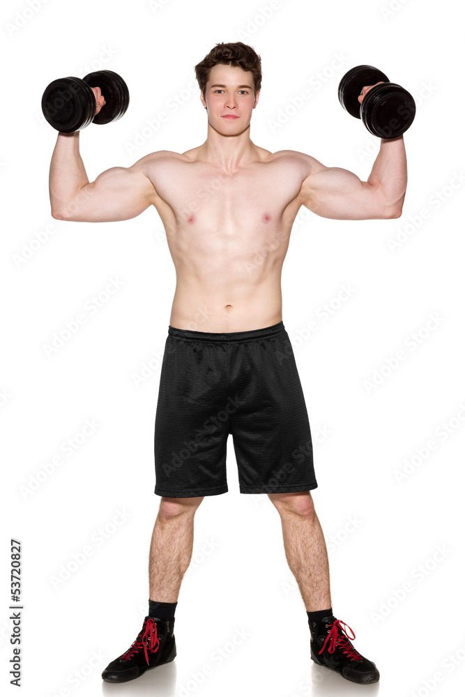 Muscular young man in full length lifting dumbbells Muscular young man in full length lifting dumbbells