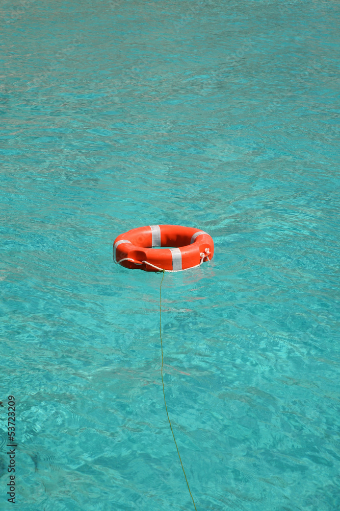 Obraz premium Orange lifesaver floating on turquoise sea