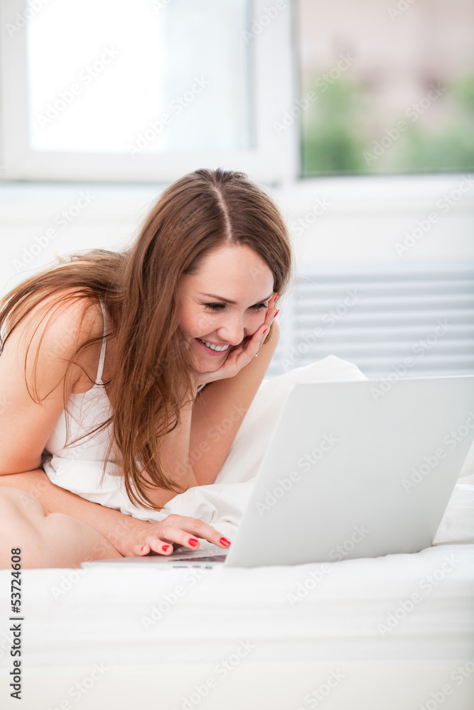 woman sittting in bed with laptop woman sittting in bed with laptop