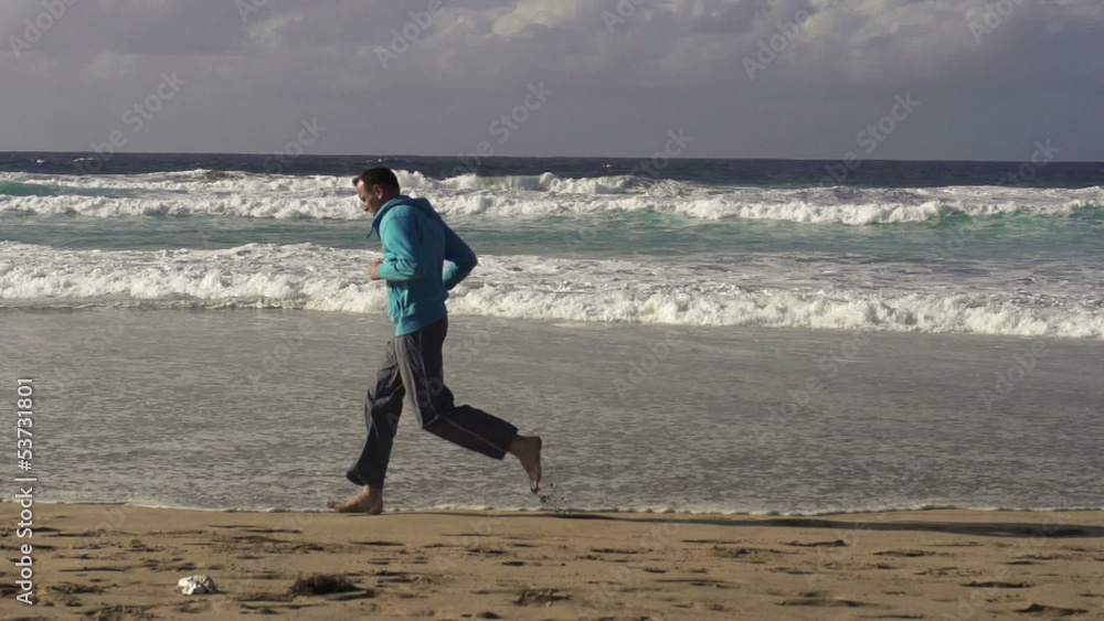 Young man jogging on the seashore, slow motion shot at 240fps Young man jogging on the seashore, slow motion shot at 240fps