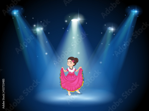A girl with a pink long dress standing in the middle of the stag
