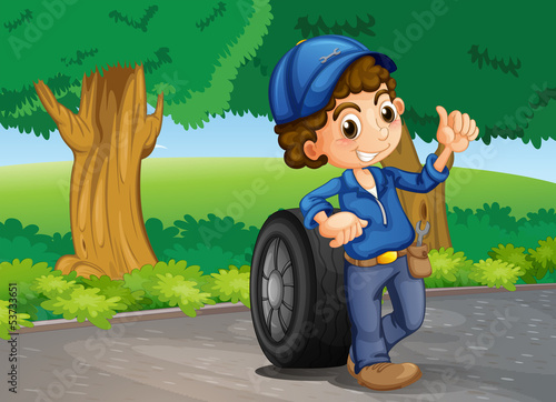 A boy and a tire at the road