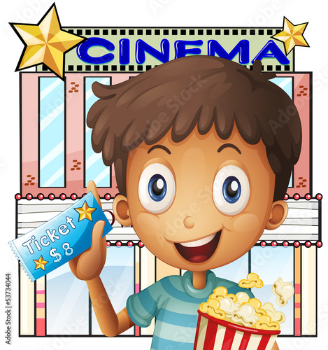 A boy holding a pail of popcorn and a ticket outside the cinema
